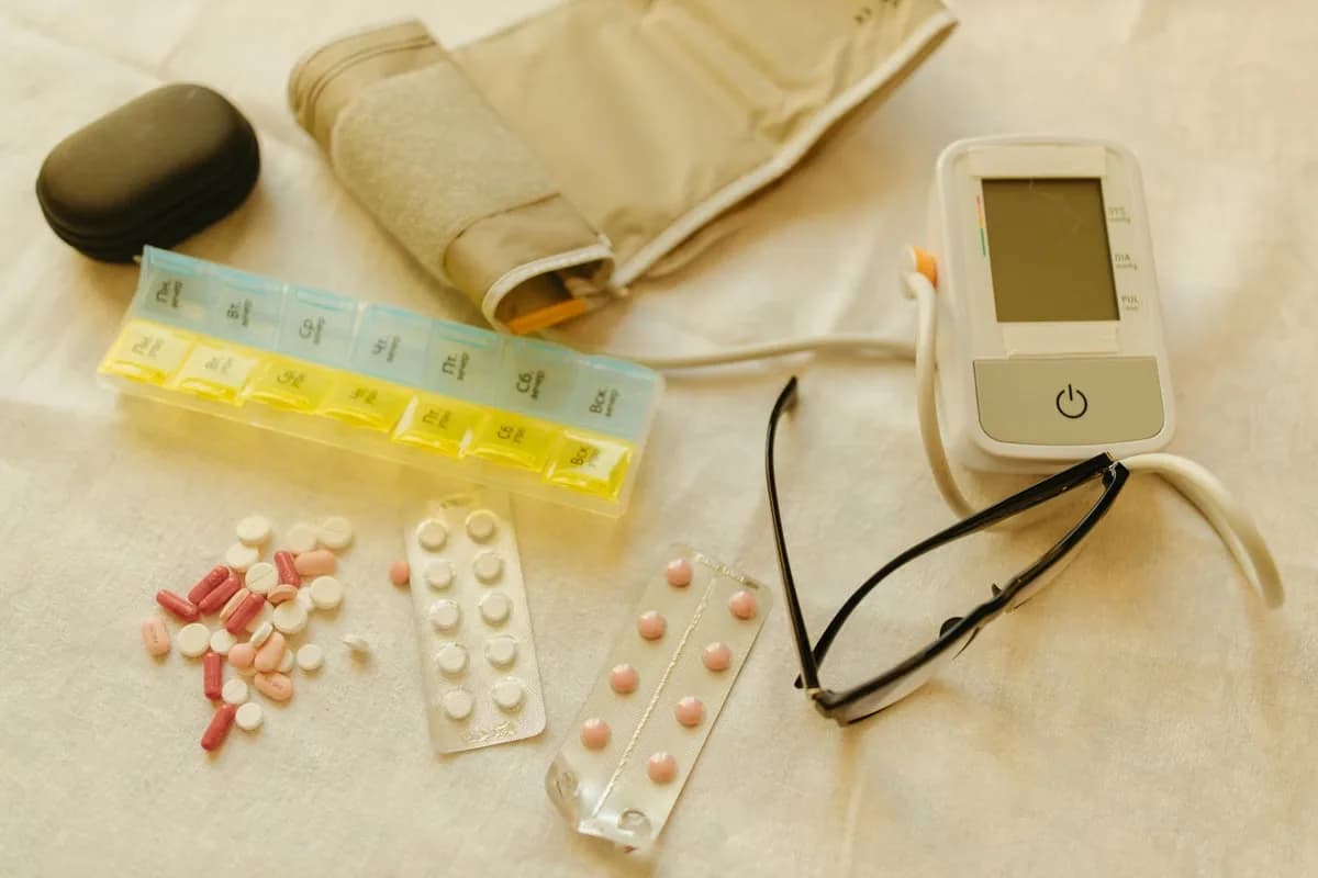 Tensimeter digital dan obat di atas kain putih
